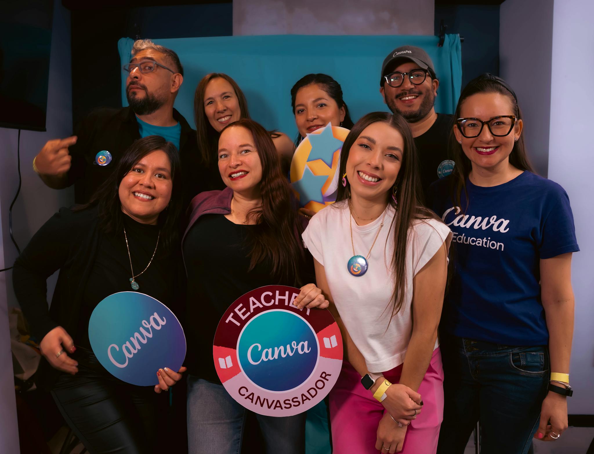Happy group of educators attending a Canva workshop, showing signs and smiles.